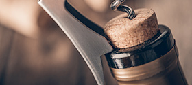 bottle of wine opened with corkscrew